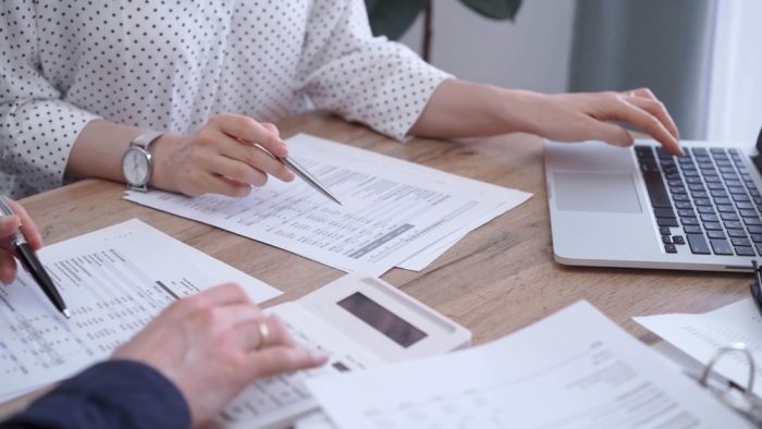 Bookkeeping accountant sitting with client and going through finances